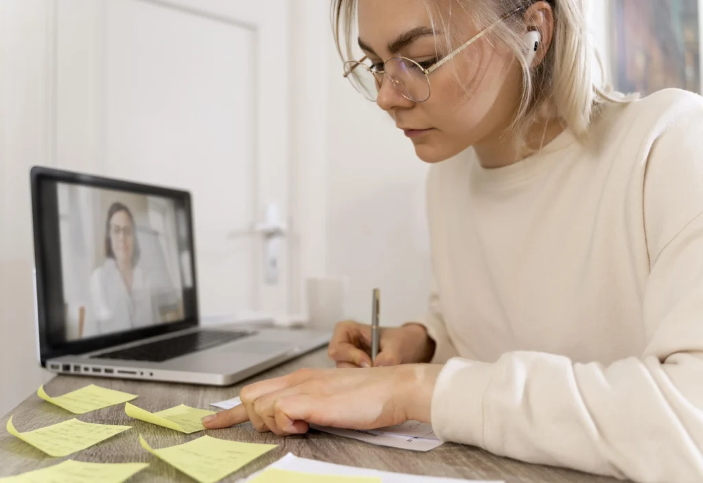 Estudiante trabajando en línea sobre temas de TFG 2025 y tomando apuntes